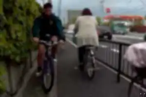 歩道上で歩行者に向かって減速せずに突っ込んでくる２台の自転車。
１台目はイヤホンをつけて運転。２台目はこちらに幅寄せしてきた悪質な運転。
自転車の通行区分違反、歩行者通行妨害、事故を起こす可能性のある危険運転。