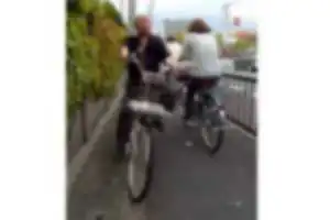 歩道上で歩行者に向かって減速せずに突っ込んでくる２台の自転車。
１台目はイヤホンをつけて運転。２台目はこちらに幅寄せしてきた悪質な運転。
自転車の通行区分違反、歩行者通行妨害、事故を起こす可能性のある危険運転。