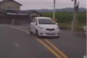 白の旧旧型ヴィッツ。
黄色二重線のセンターラインをはみ出して曲がるルーズすぎる運転。