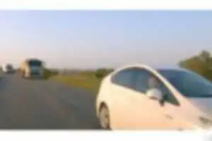 黄色センターラインはみ出しトラック２台抜きの白プリウス